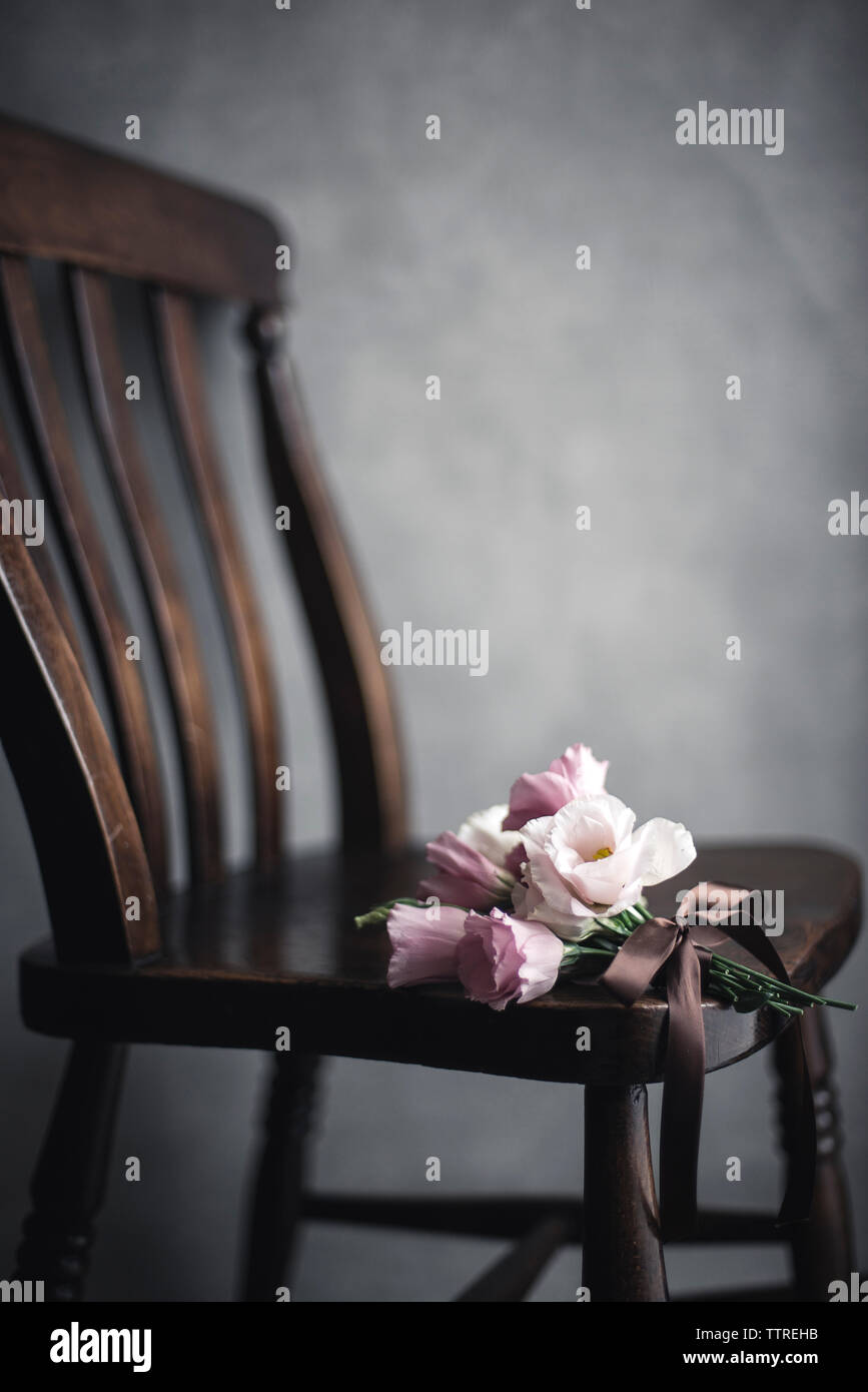 Bunch of flowers on wooden chair in room Stock Photo