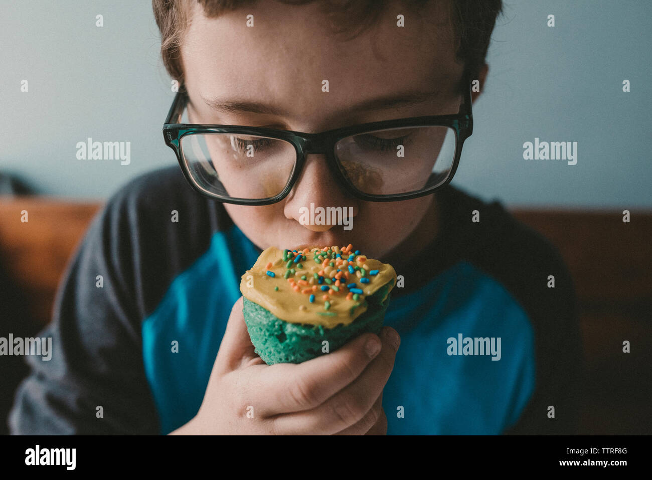 Close-up of boy eating cupcake at home Stock Photo