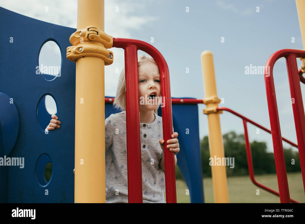 Boy playing on outdoor play equipment at playground Stock Photo