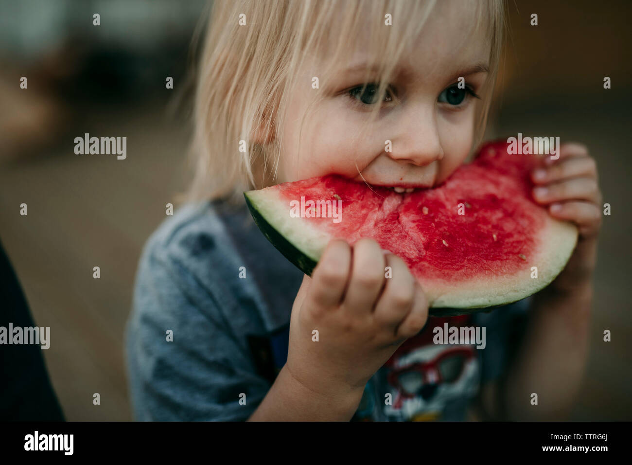 Cute boy eating watermelon at porch Stock Photo