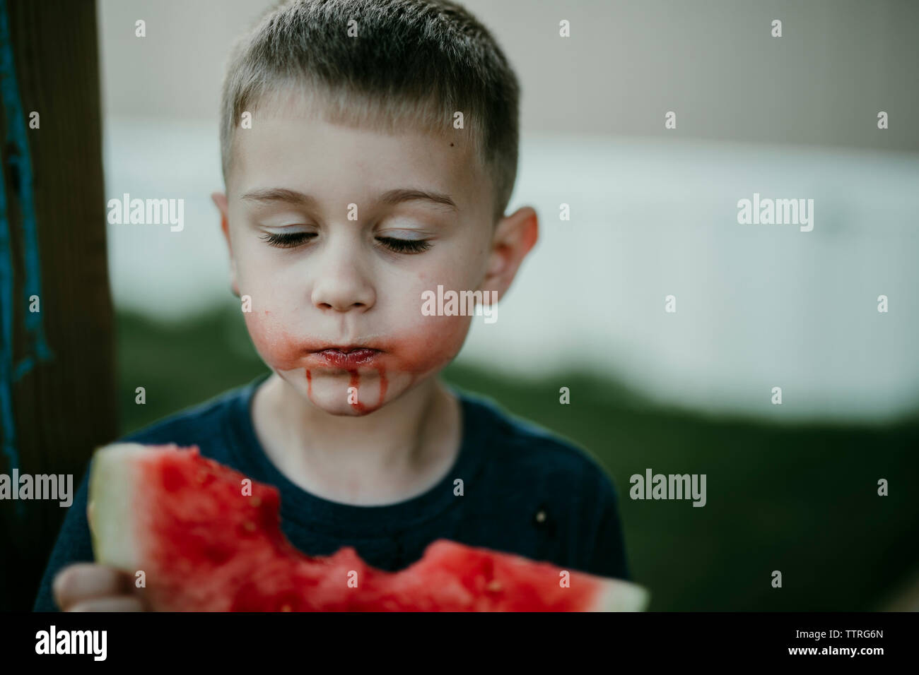 Boy with eyes closed eating watermelon Stock Photo