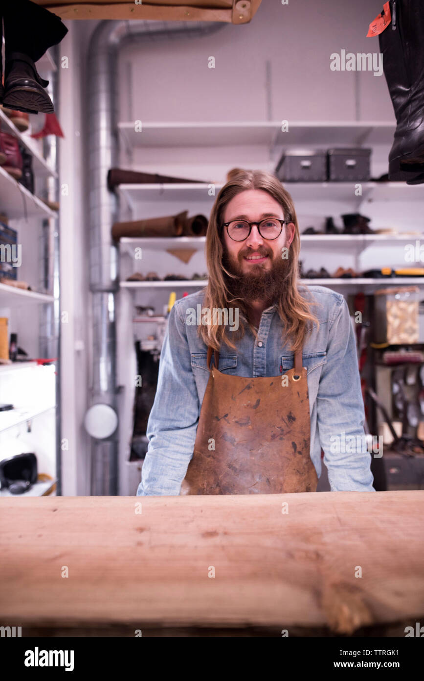 Portrait of smiling shoemaker standing in workshop Stock Photo