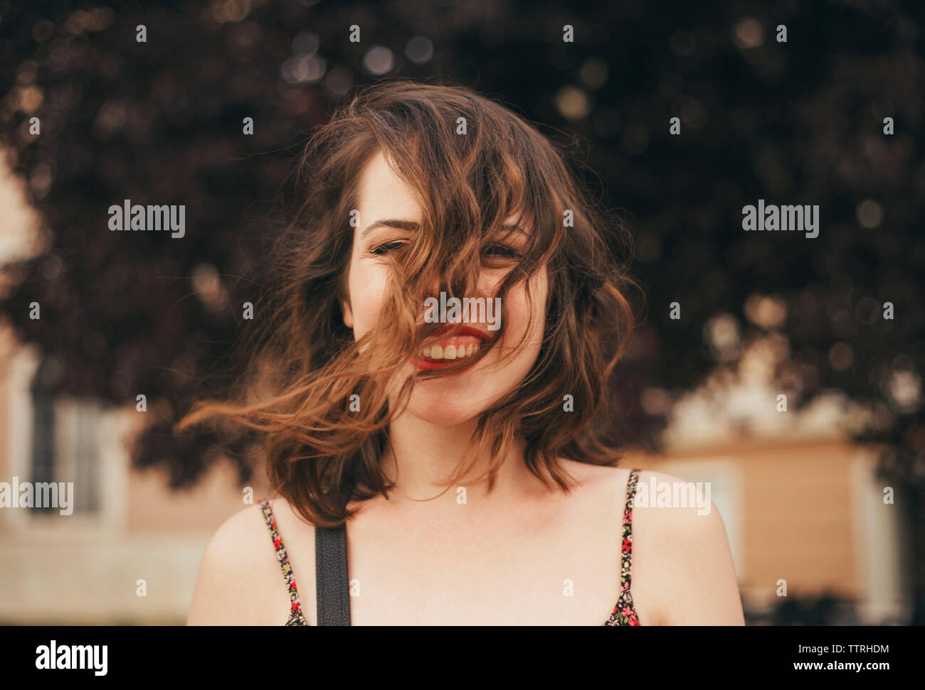 Portrait of happy young woman with tousled hair outdoors Stock Photo