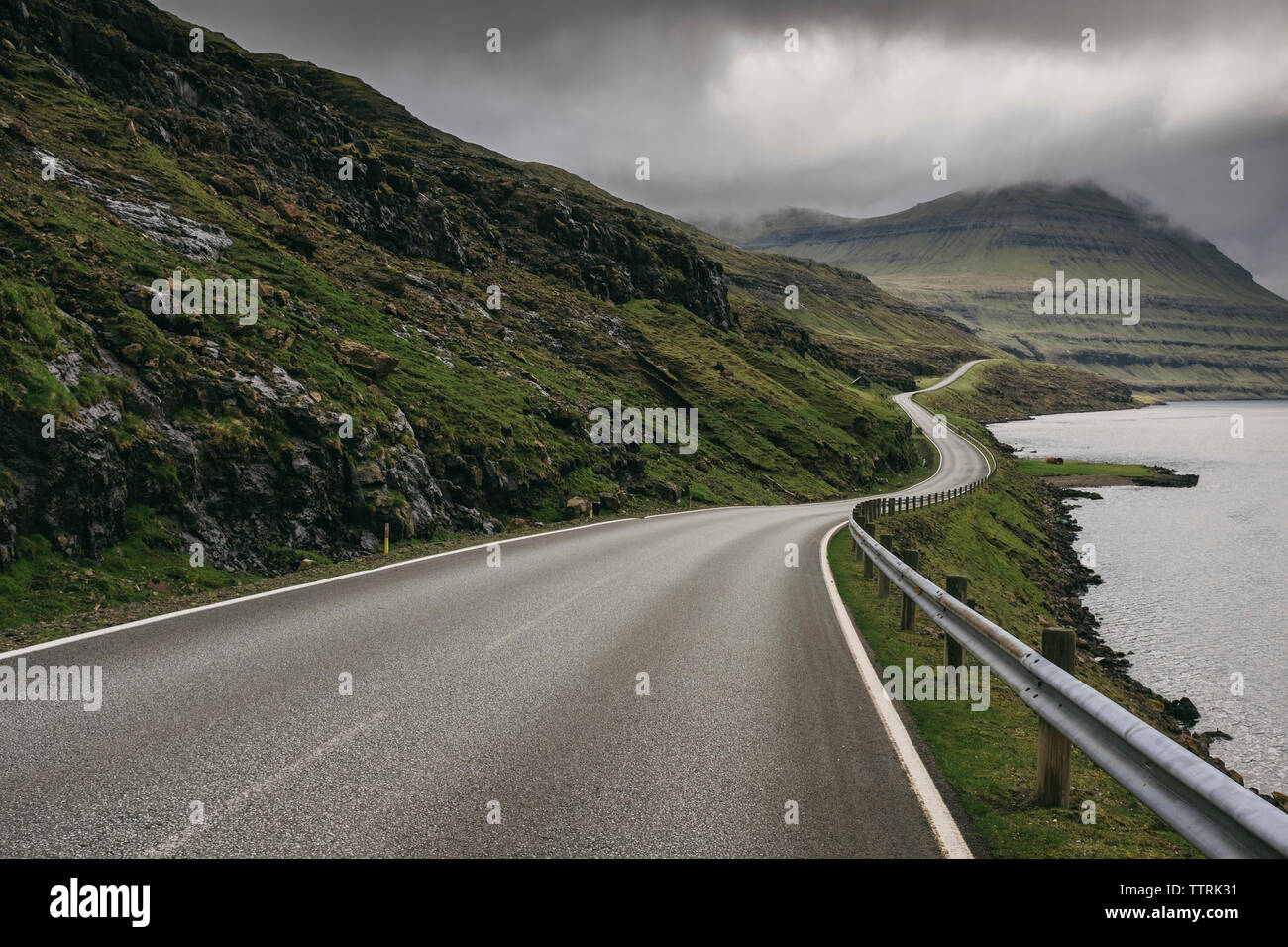 Winding road against stormy clouds Stock Photo - Alamy