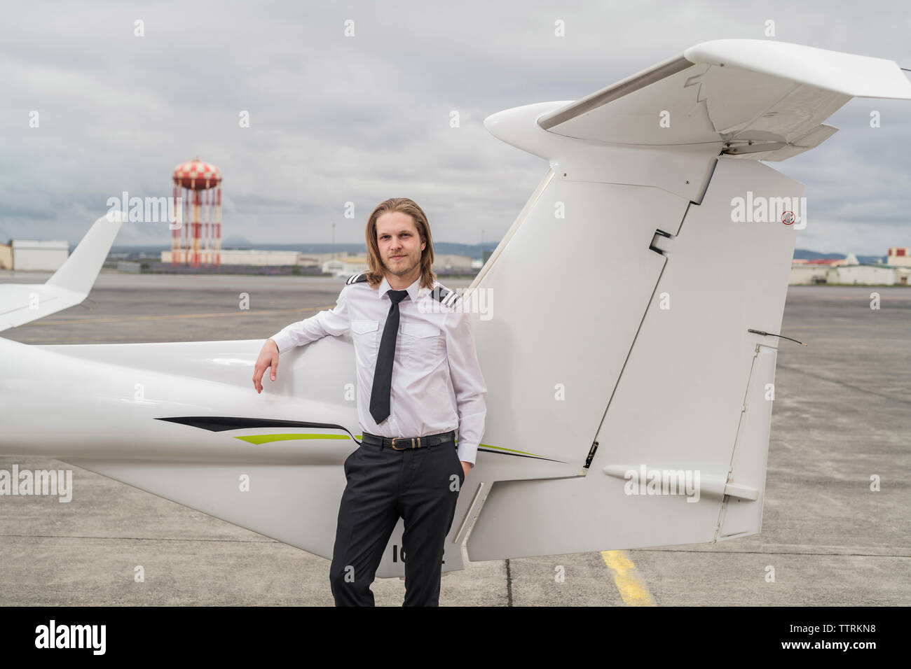 Smiling male pilot standing airplane hires stock photography and