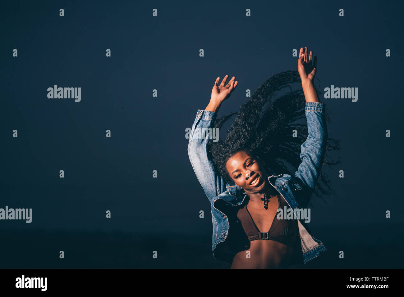 Portrait African woman raising her arms and moving her hair Stock Photo ...