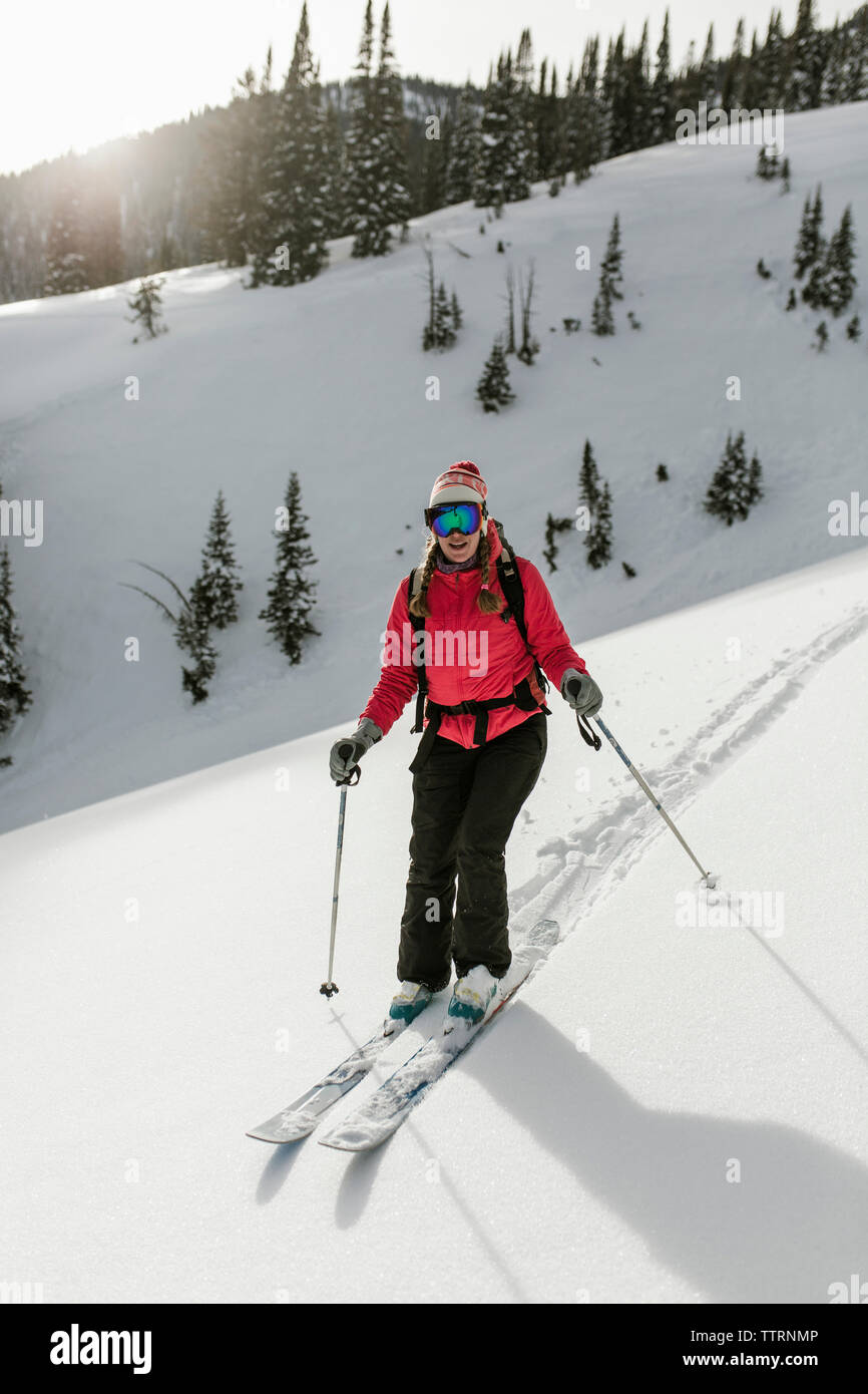 Woman skiing on snow covered mountain at forest Stock Photo