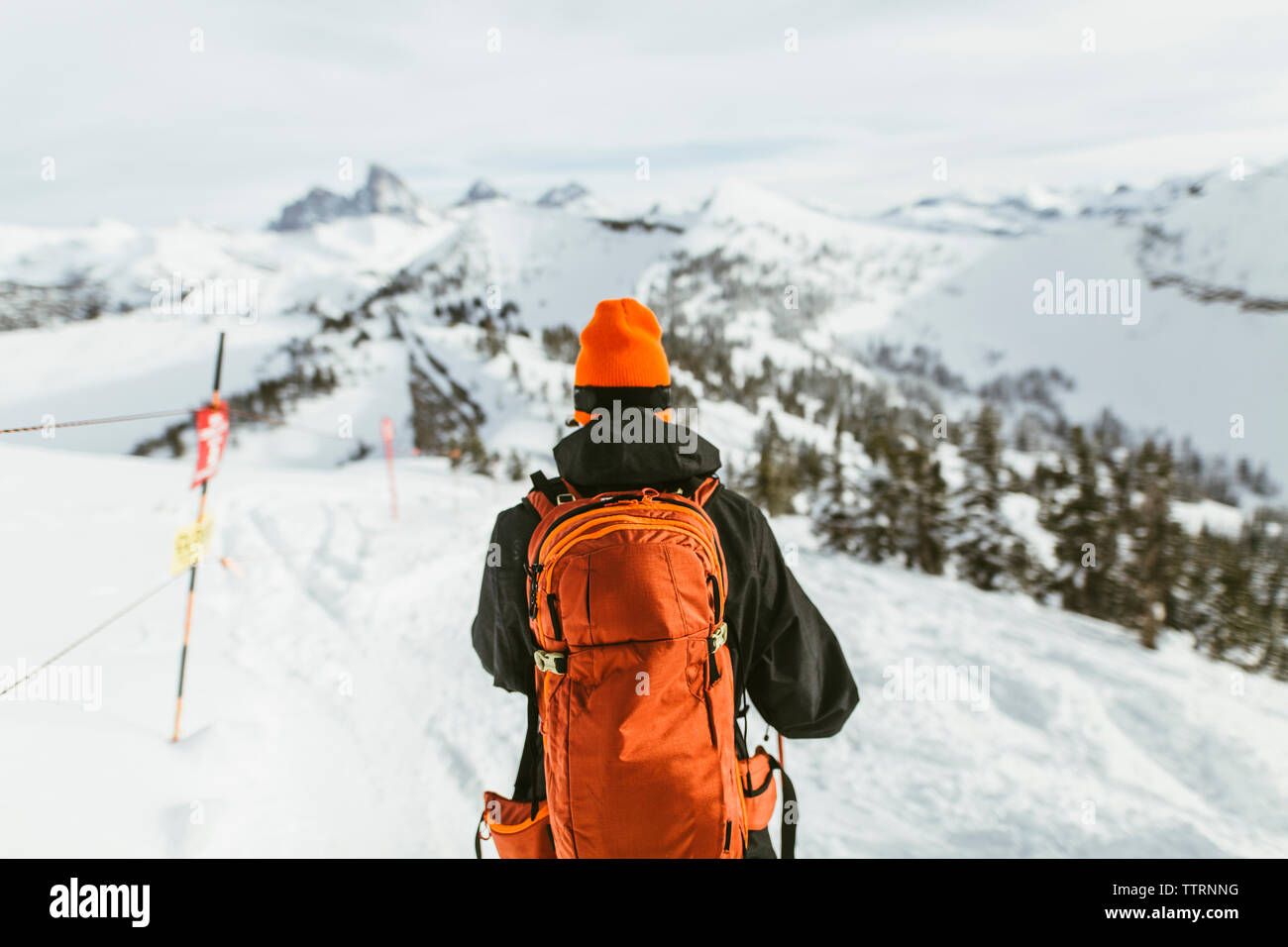 Rear view of hiker with backpack on snowcapped mountain during ski holiday Stock Photo