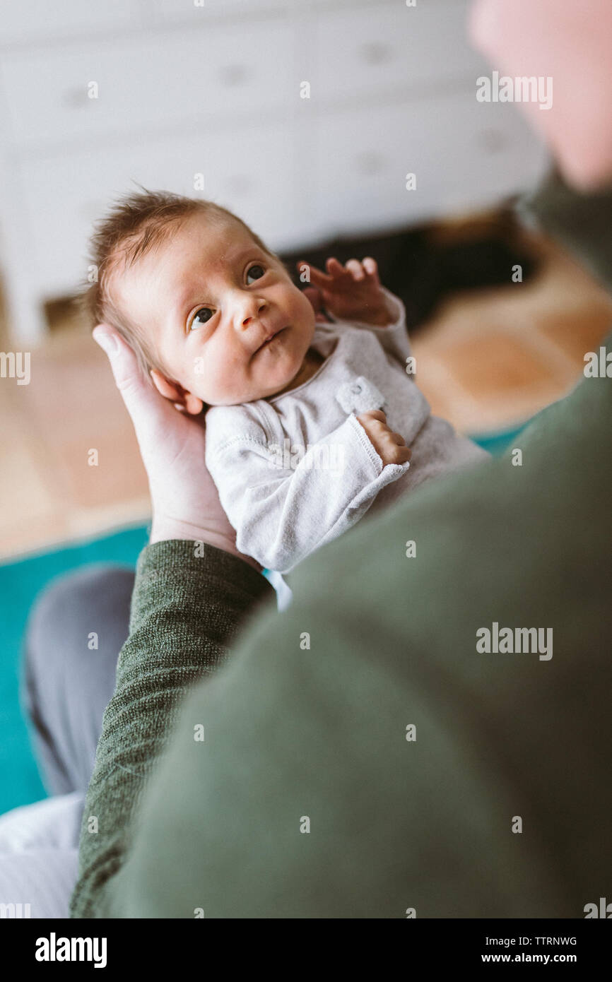 newborn baby girl in dad's arms making eye contact Stock Photo