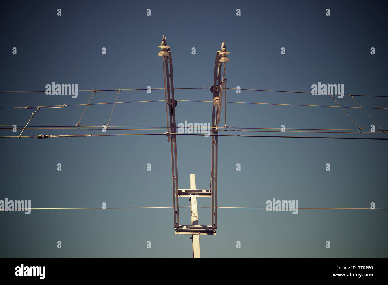 Low angle view of overhead lines against clear sky Stock Photo