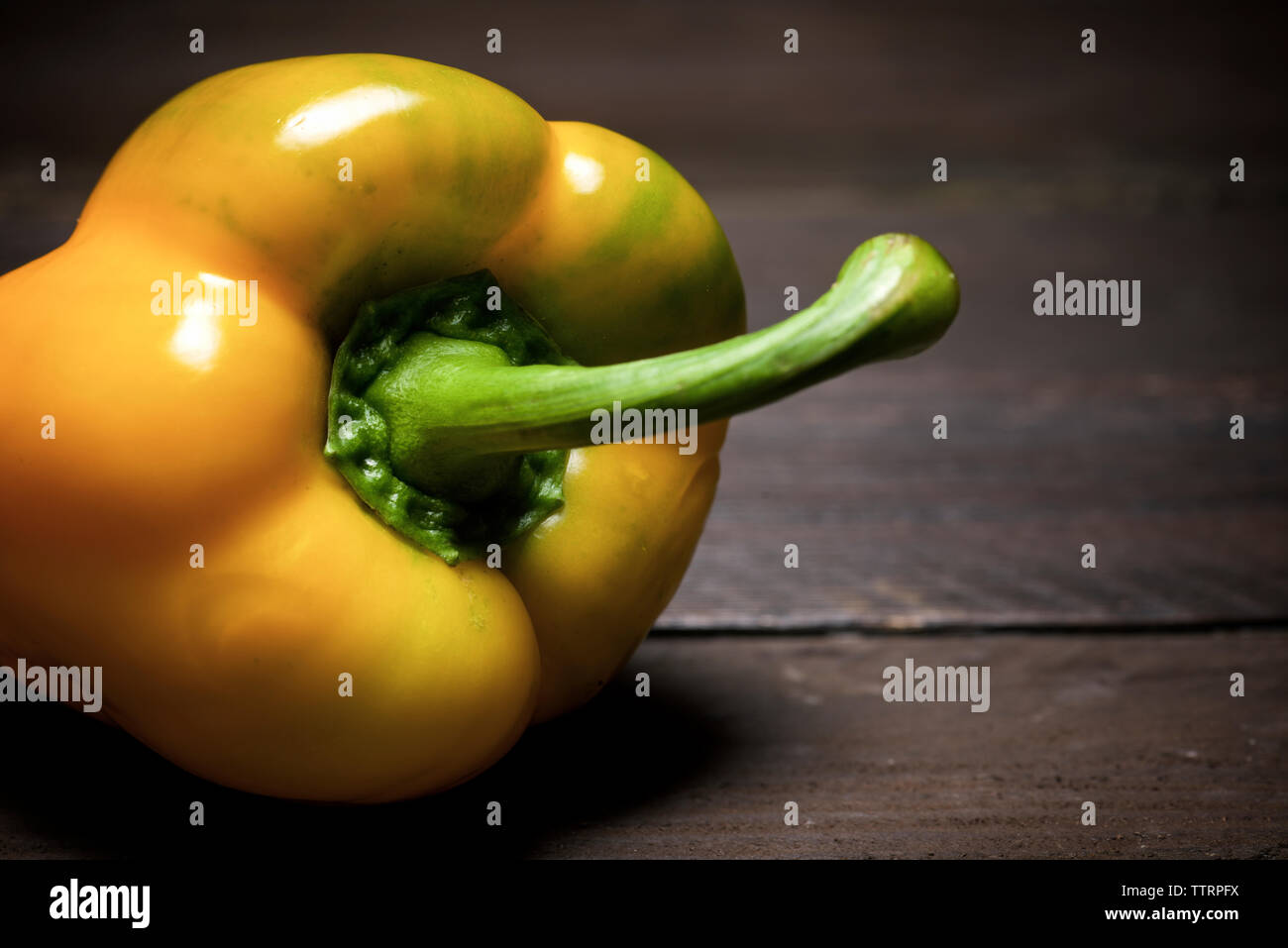 Close-up of yellow bell pepper on wooden table Stock Photo