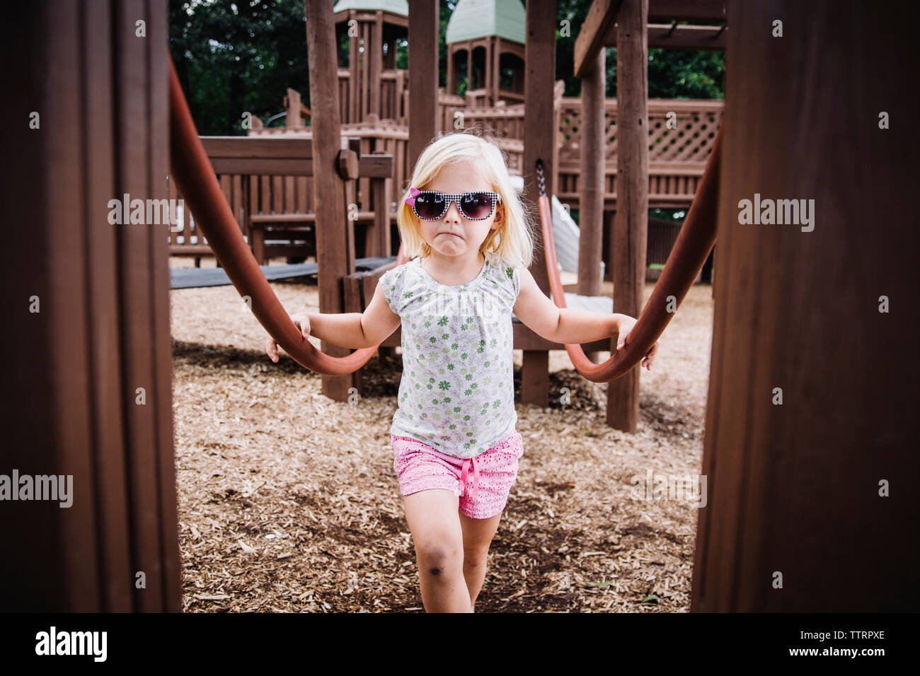 Portrait of girl wearing sunglasses while standing at playground Stock Photo