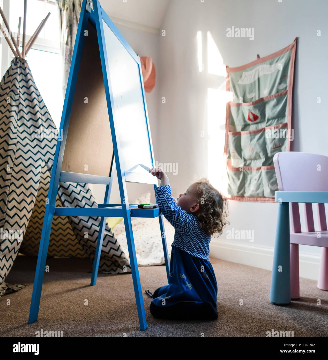 Girl writing on artist's canvas while sitting on rug at home Stock ...