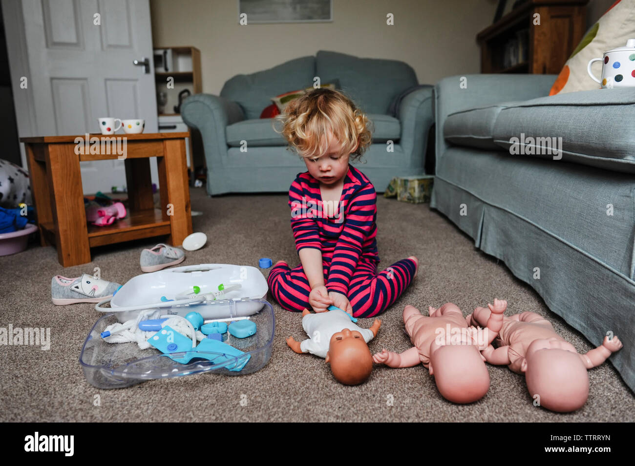 Girl playing with dolls at home Stock Photo