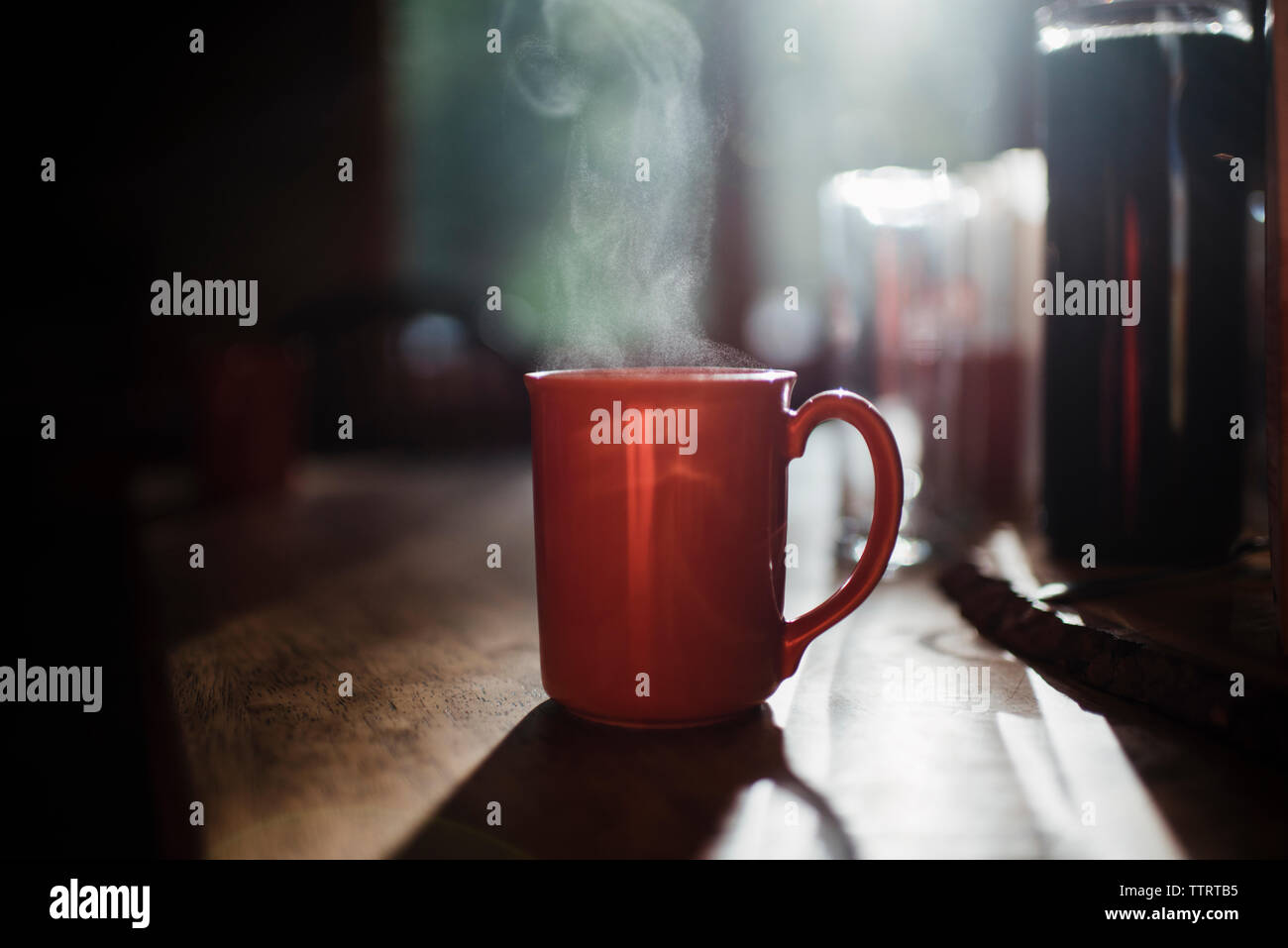 Close-up of steam emitting from coffee cup on table at home Stock Photo