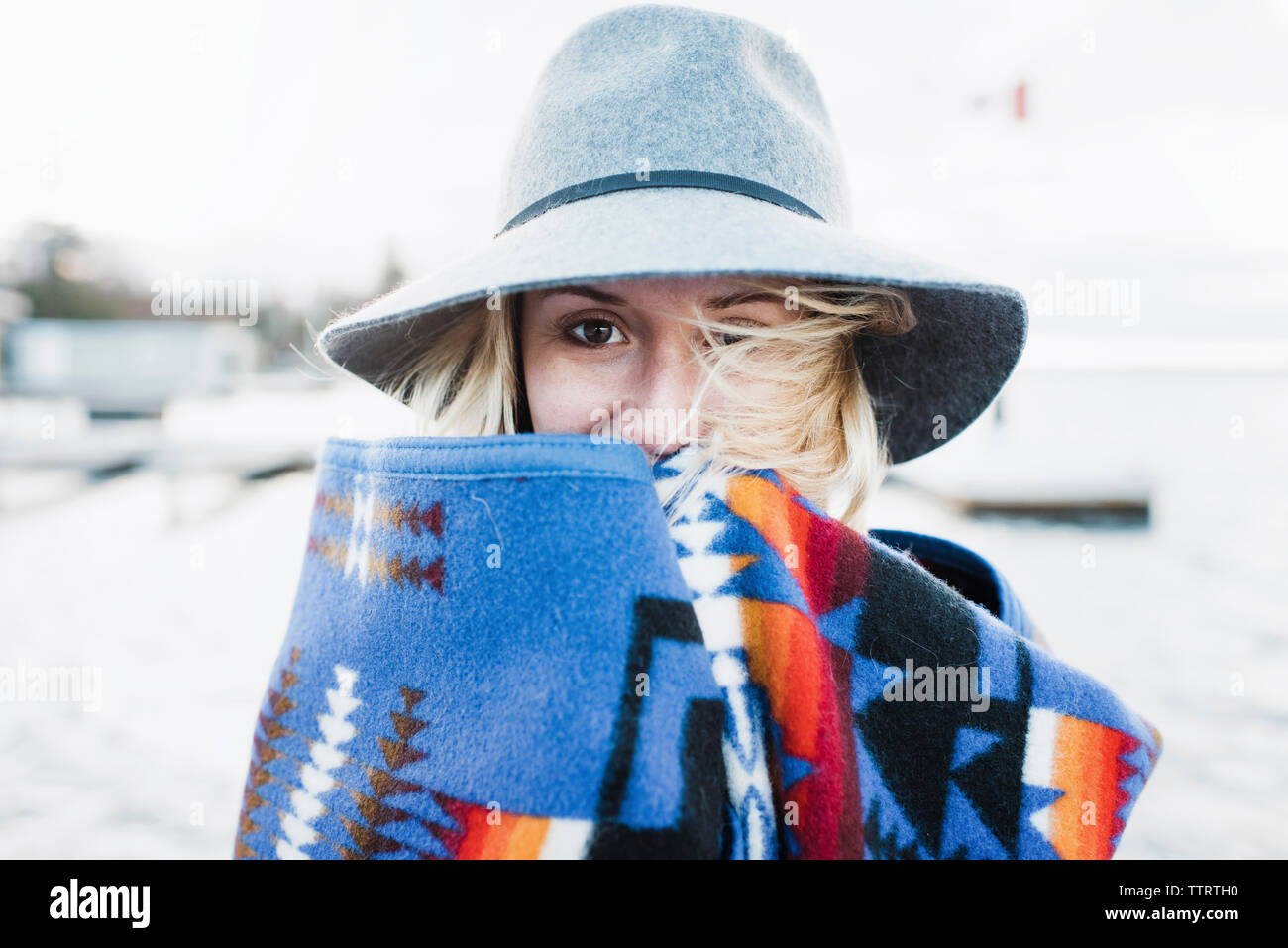 Portrait of woman wrapped in blanket standing by Lake Simcoe Stock Photo