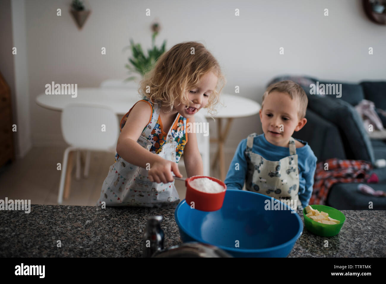 Siblings preparing food at home Stock Photo