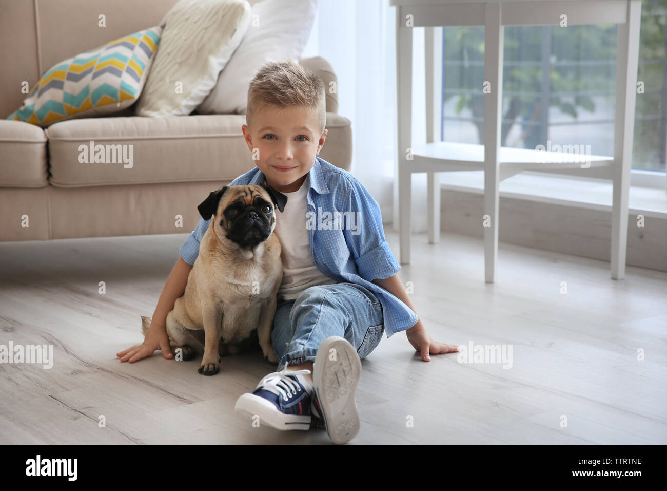 Cute boy with pug dog on floor Stock Photo - Alamy