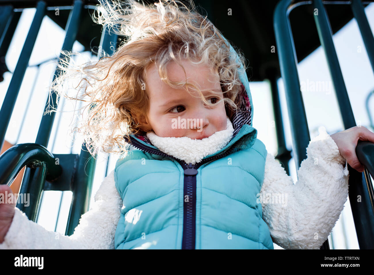Low angle view of girl playing on slide at playground Stock Photo