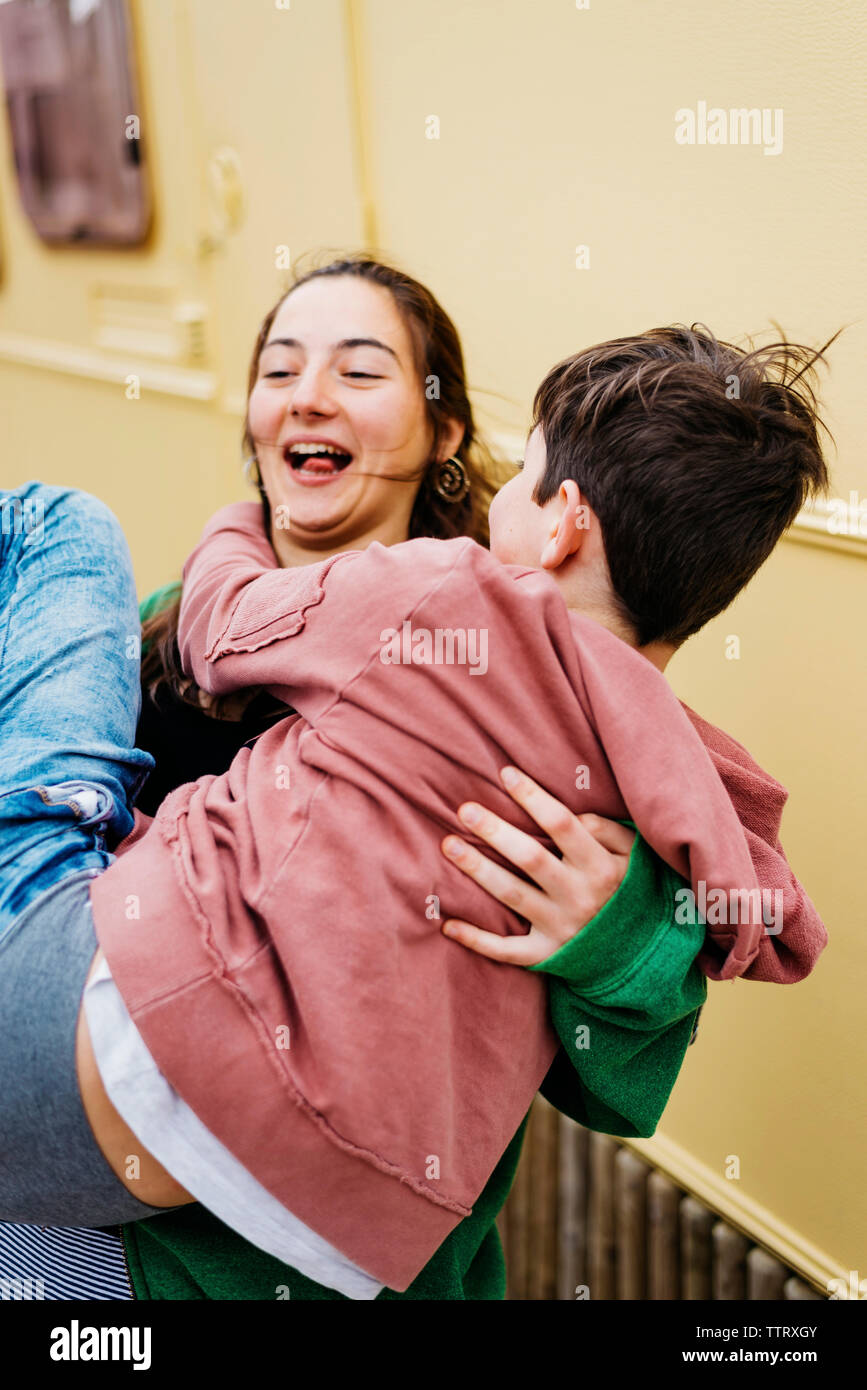 Brothers enjoying outdoors in sunny day, girl holding in arms boy Stock ...