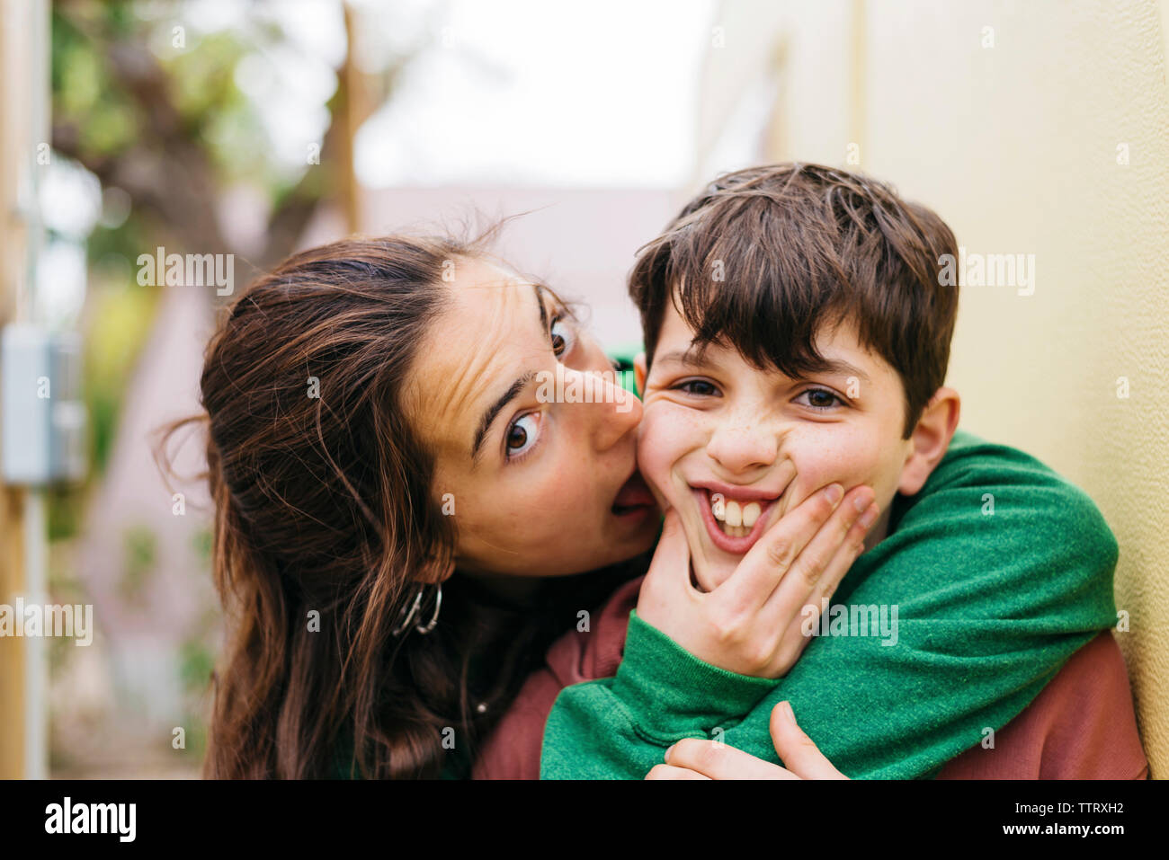 Young woman licking her brother while looking camera outdoors Stock Photo