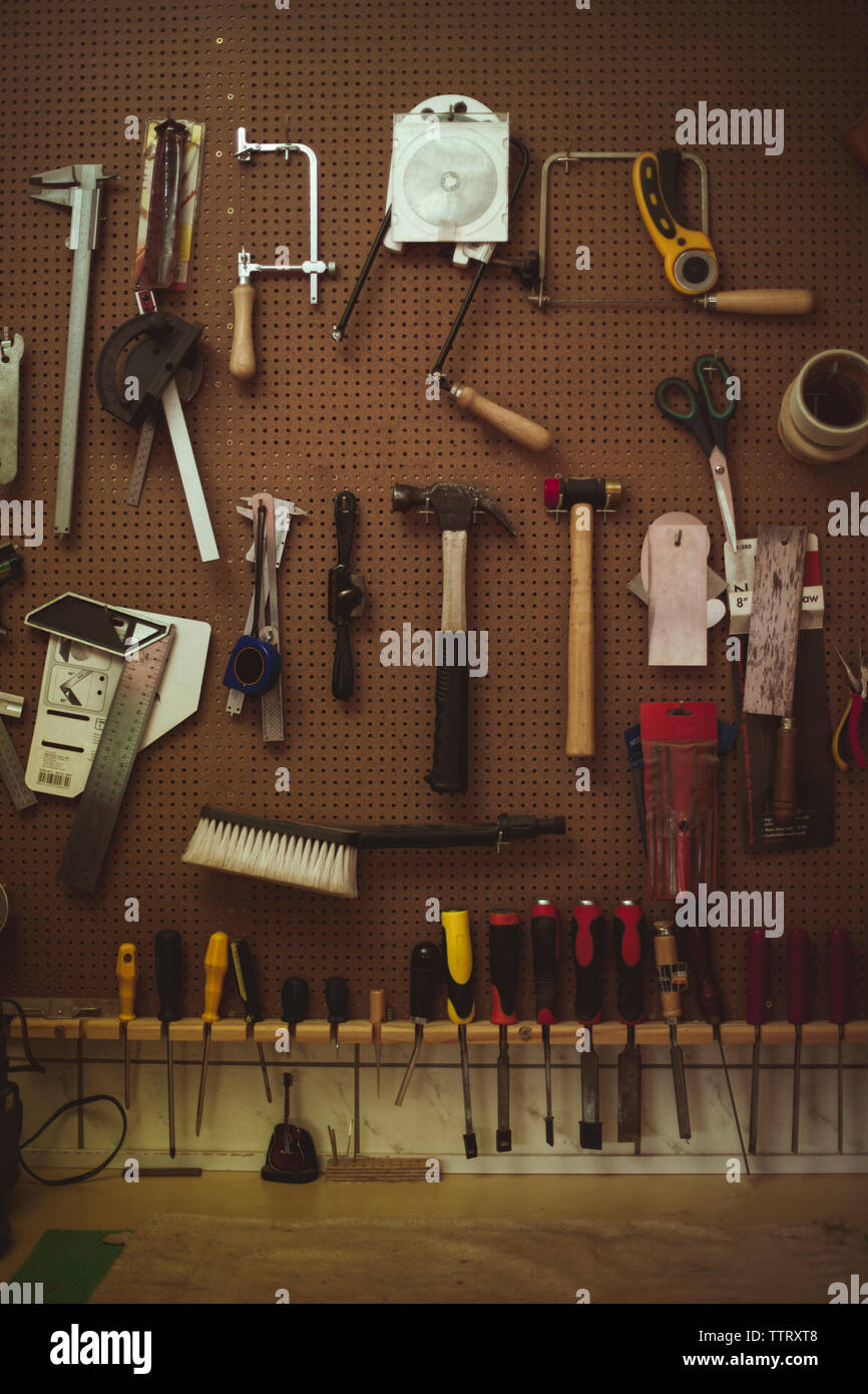 Hand tools hanging on pegboard at guitar workshop Stock Photo