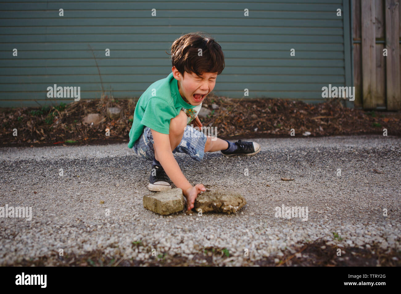 Boy imitating to break stones while practicing karate on street Stock Photo
