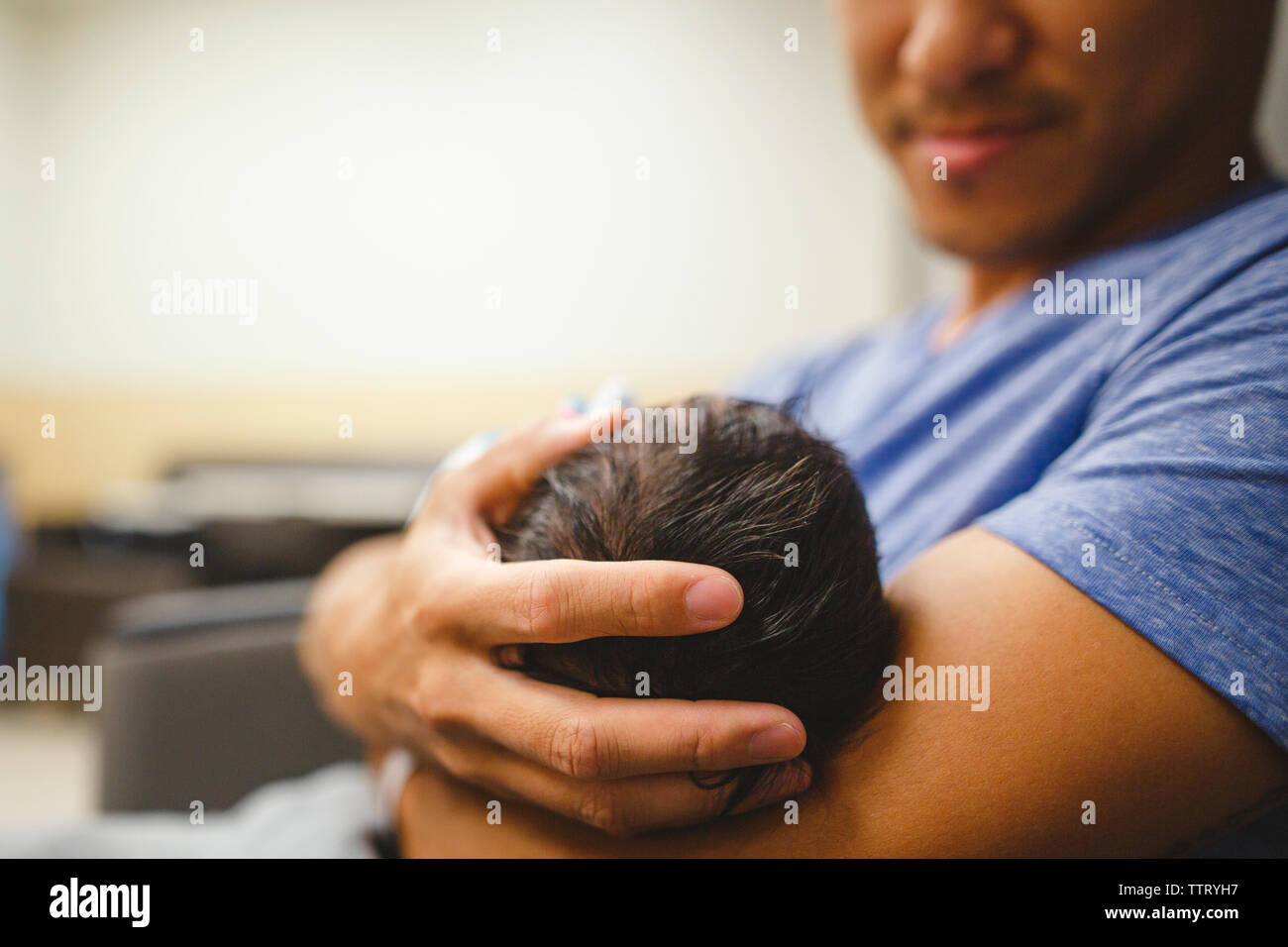 a proud father gently holds his daughter in his arms cradling her head
