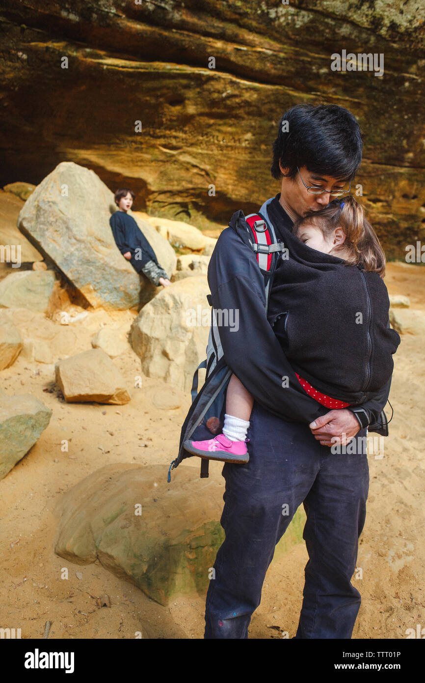 A loving father hikes with his small children through a rocky gorge Stock Photo