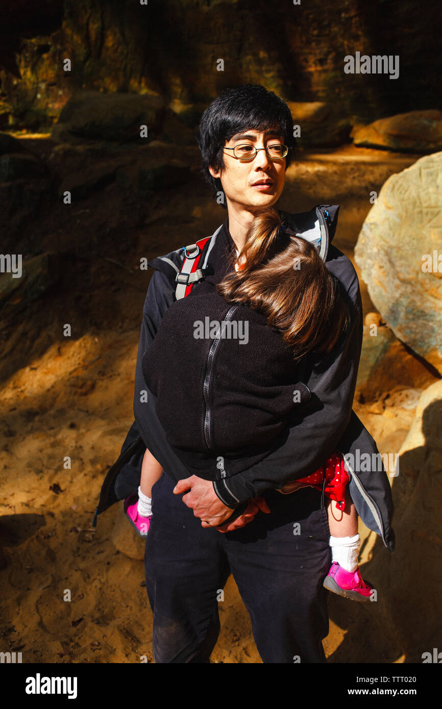 Portrait of father protecting his little girl inside his coat on hike Stock Photo
