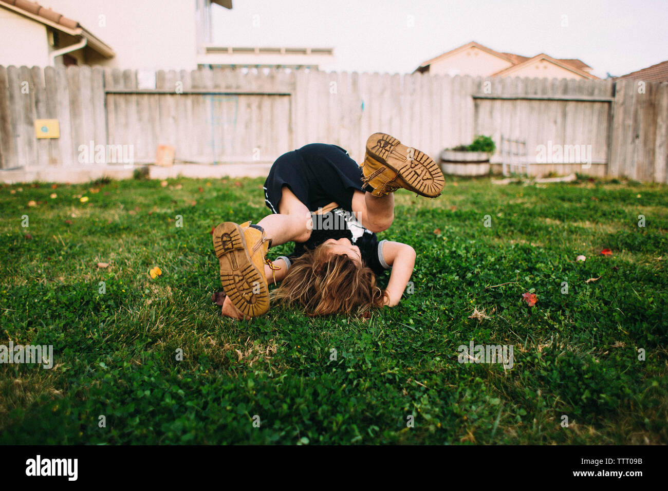 Happy girl playing on grassy field in backyard Stock Photo - Alamy