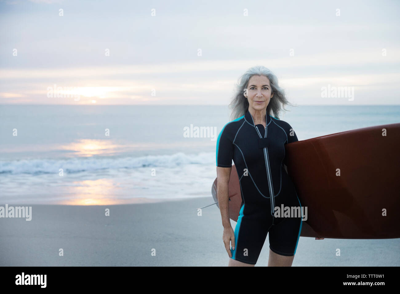 Portrait of confident female surfer carrying surfboard at Delray Beach Stock Photo