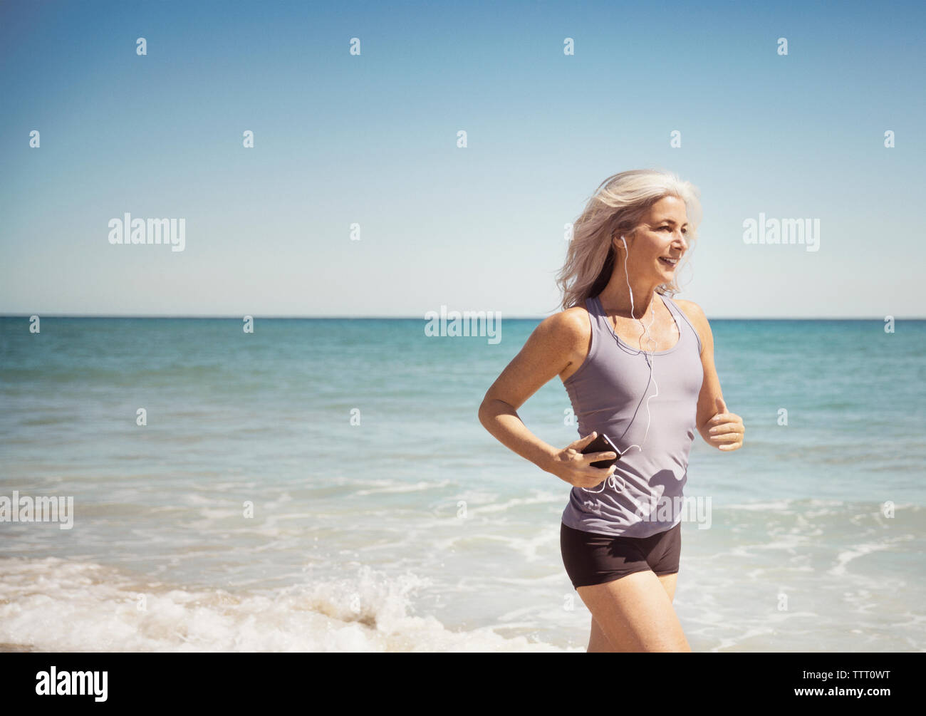 Full length of fit woman running on sea shore at Delray beach Stock Photo
