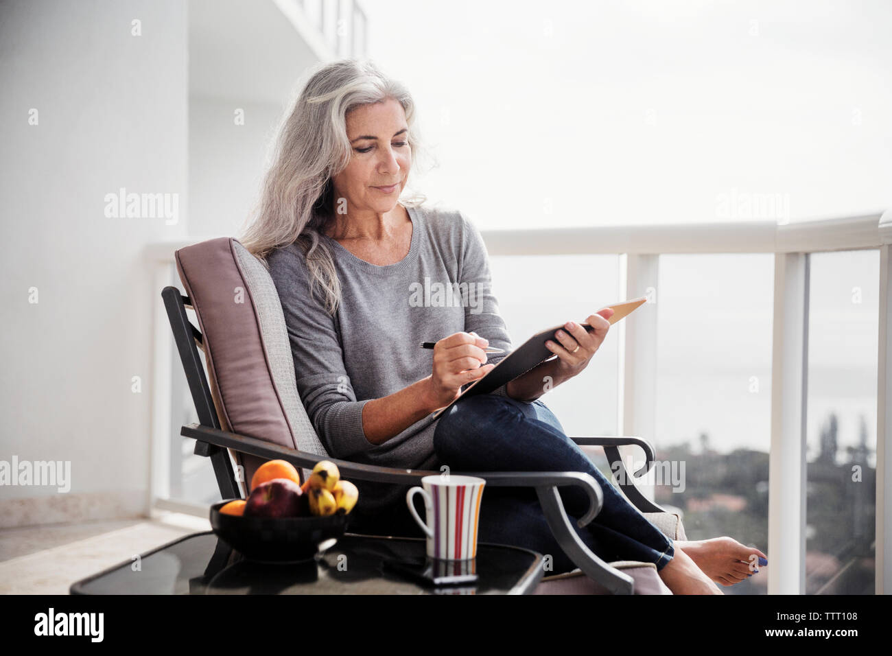 Mature woman sitting on chair hi-res stock photography and images - Alamy