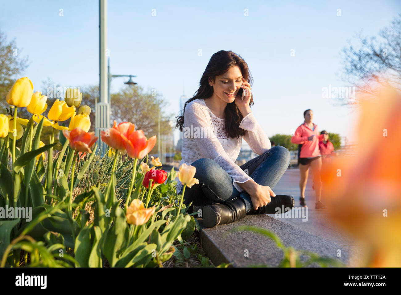 Young woman sitting wall city hi-res stock photography and images - Alamy