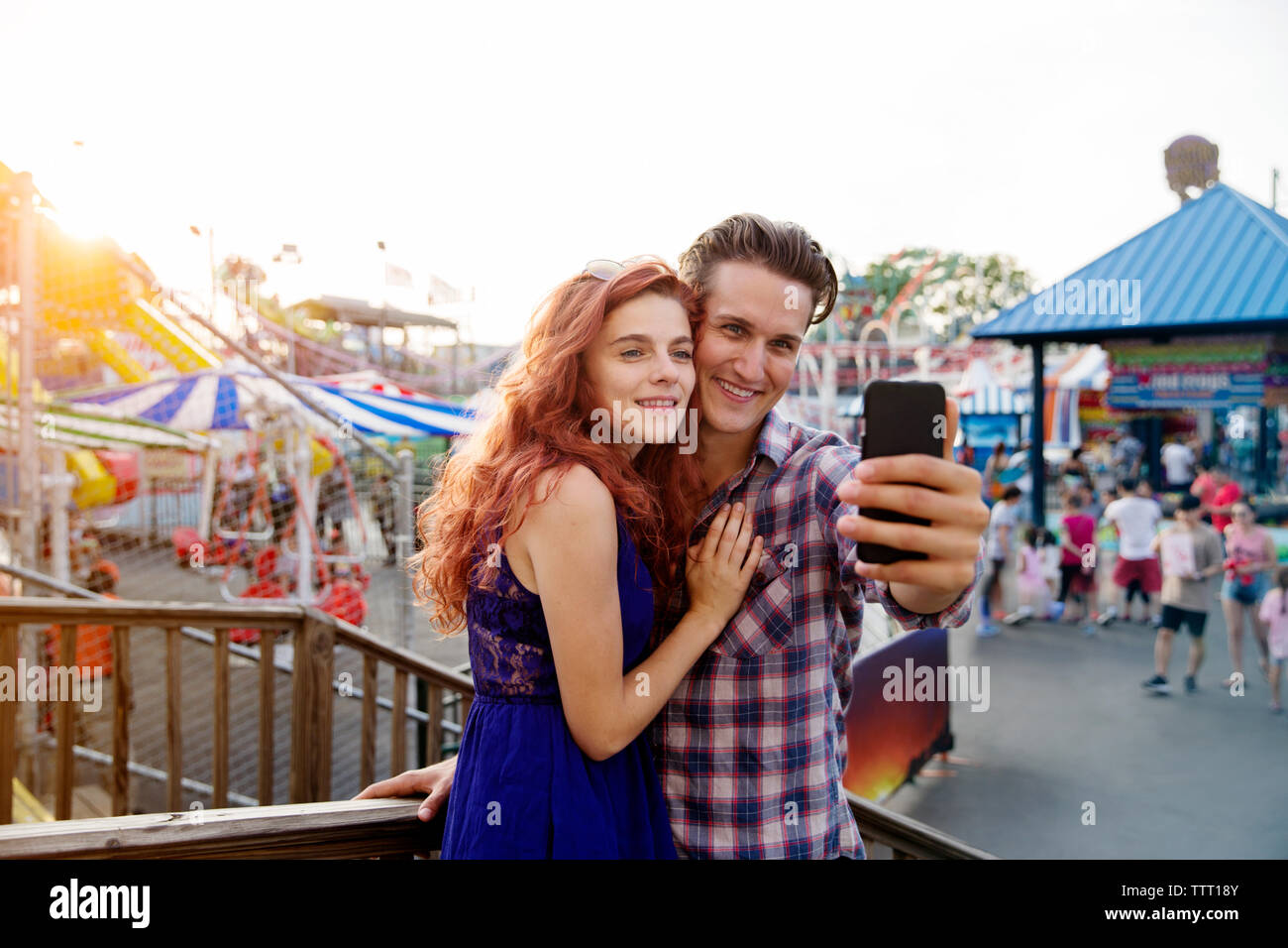 Young couple taking selfie at amusement park Stock Photo