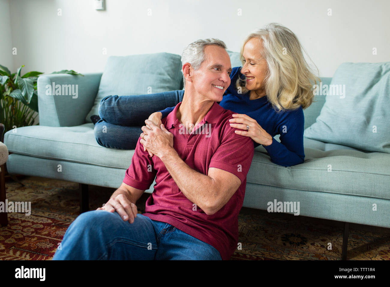 Happy couple talking while resting in living room at home Stock Photo