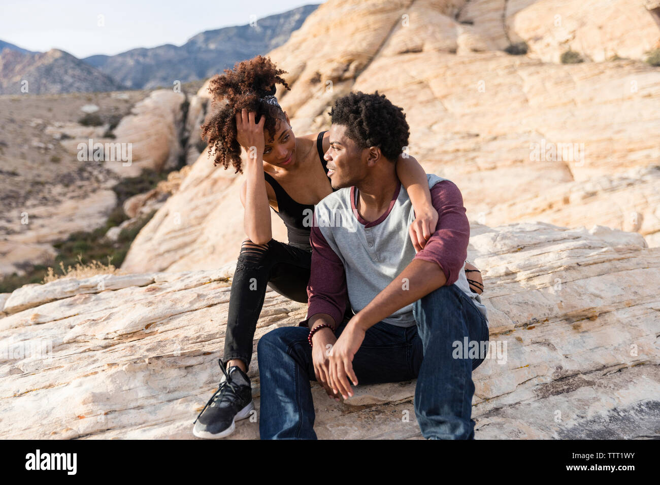Male and female sitting on rock hi-res stock photography and images - Alamy
