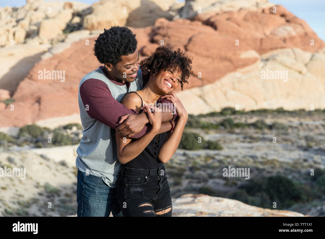 Romantic couple standing against rock formation Stock Photo