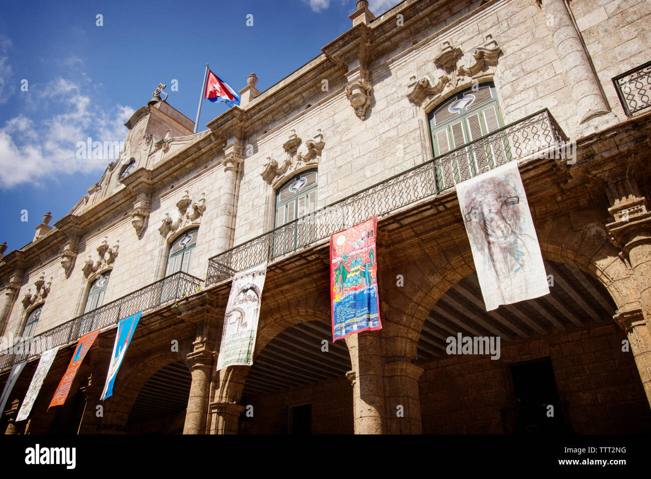 Low angle view of flags hanging from historic building Stock Photo