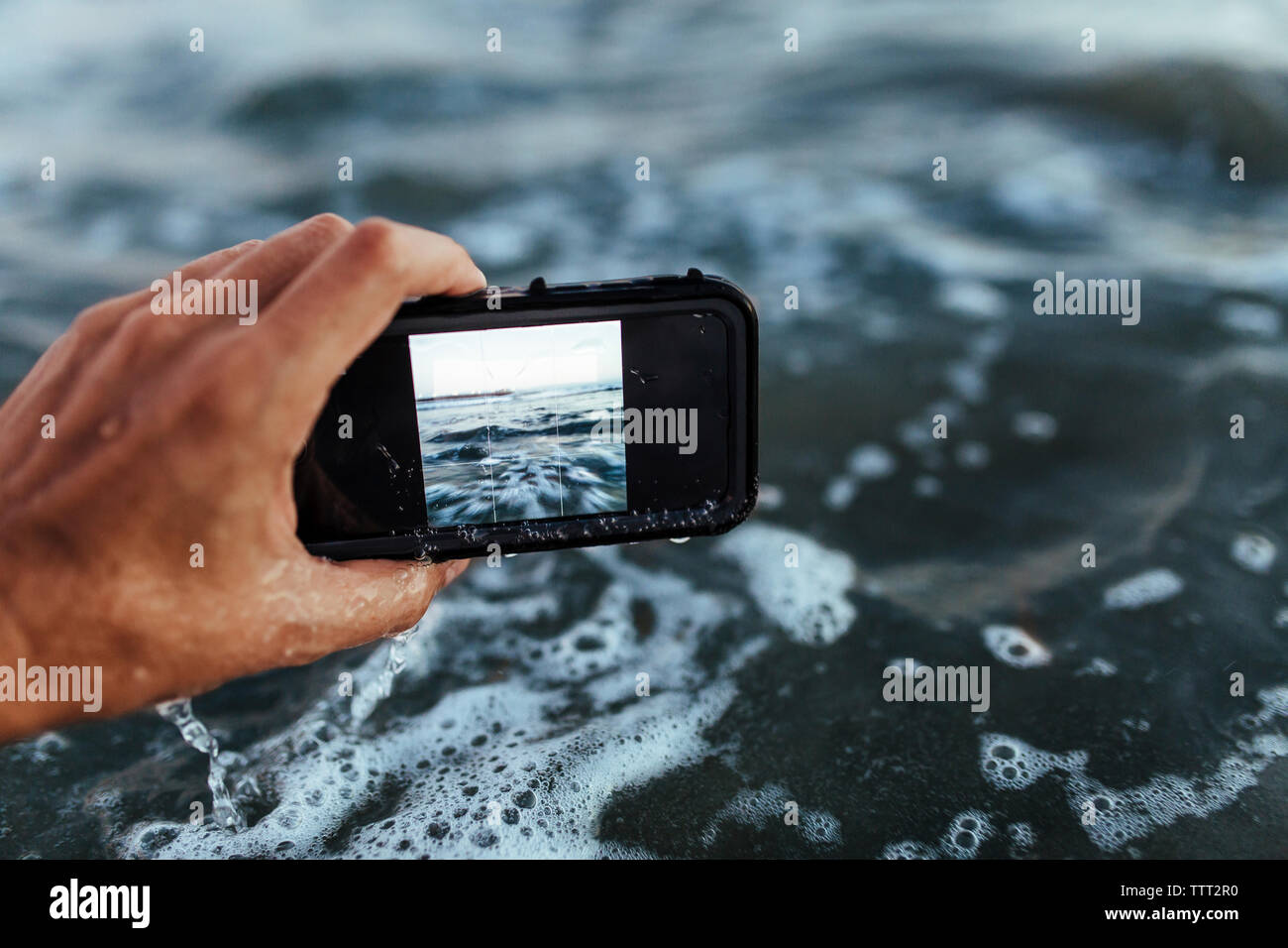 Cropped hand photographing sea Stock Photo
