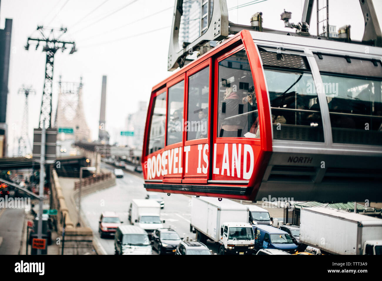 Tourists in overhead cable car traveling at city Stock Photo