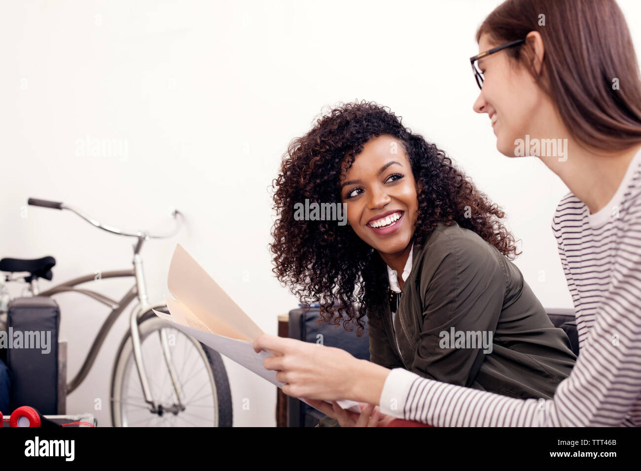 Happy businesswomen discussing over documents at office Stock Photo