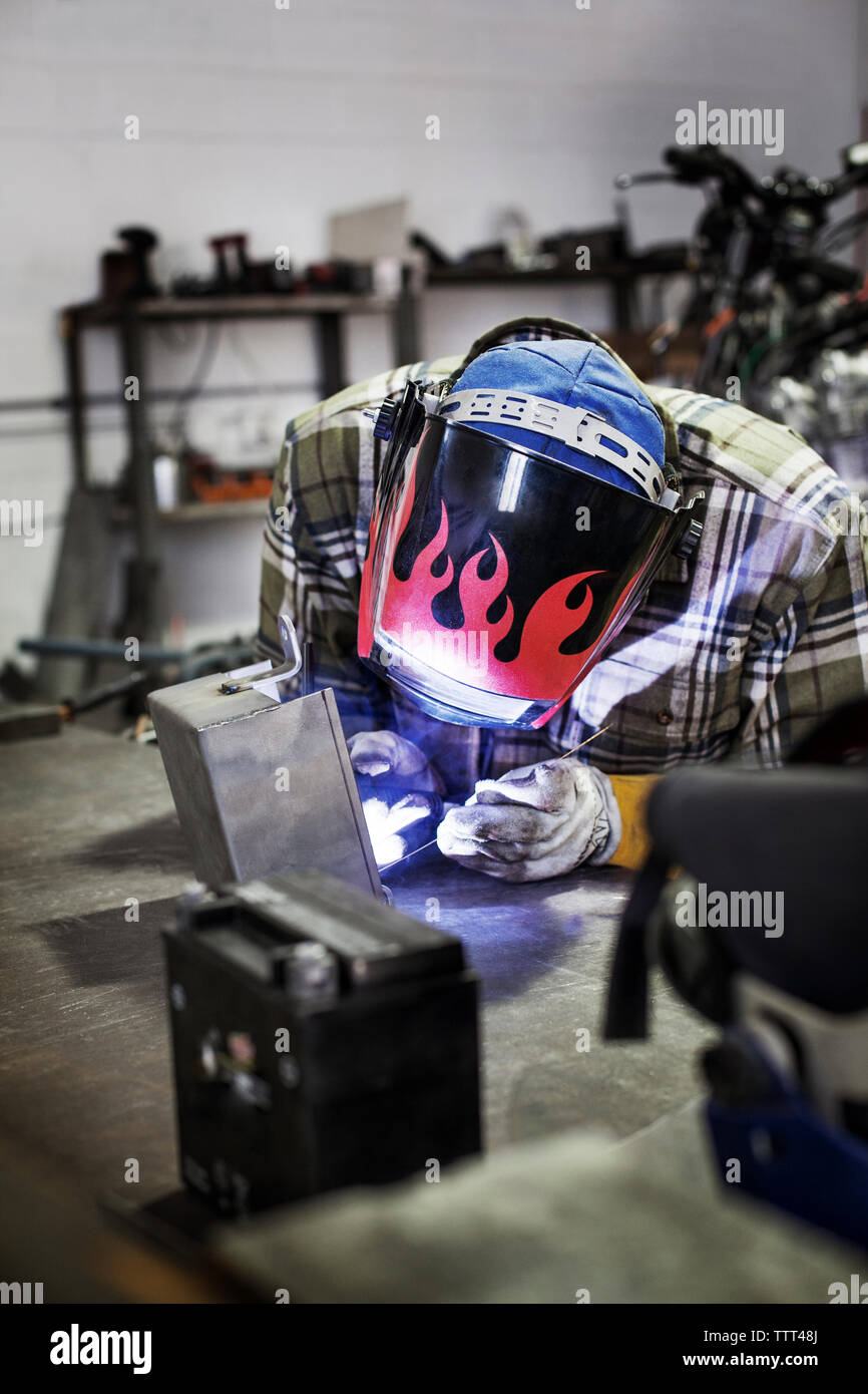 Mechanic welding metal at auto repair shop Stock Photo