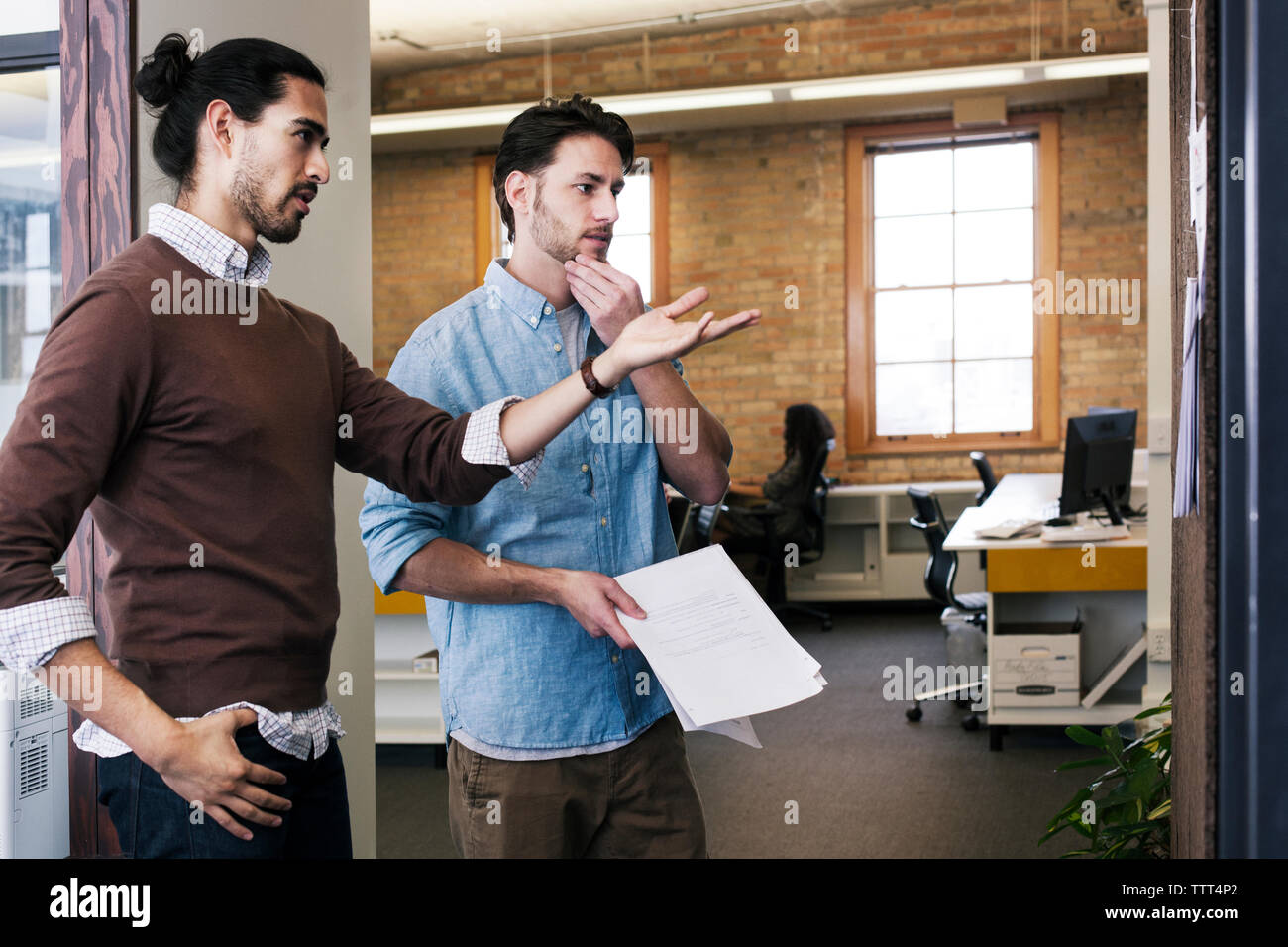 business people discussing while standing in office Stock Photo