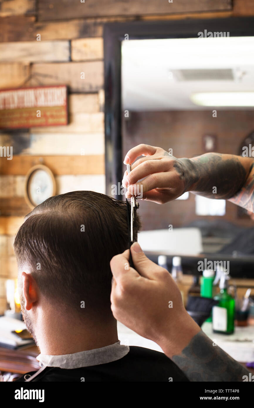 Cropped image of hands cutting man's hair in barber shop Stock Photo