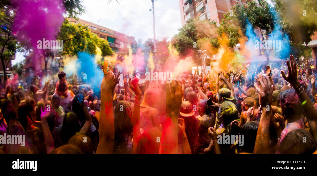 People celebrating Holi festival on city street Stock Photo