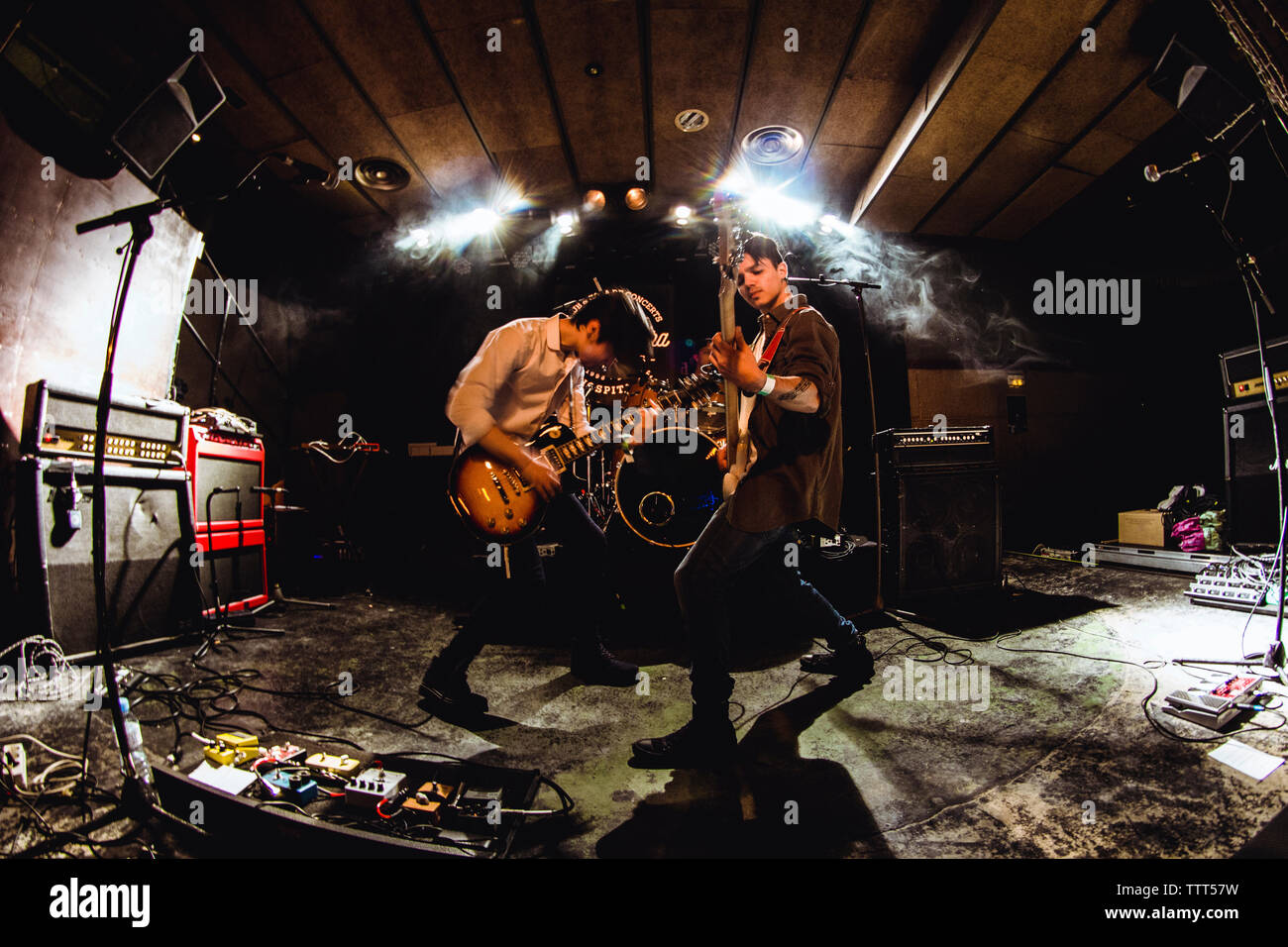 Male performers playing guitars in nightclub Stock Photo