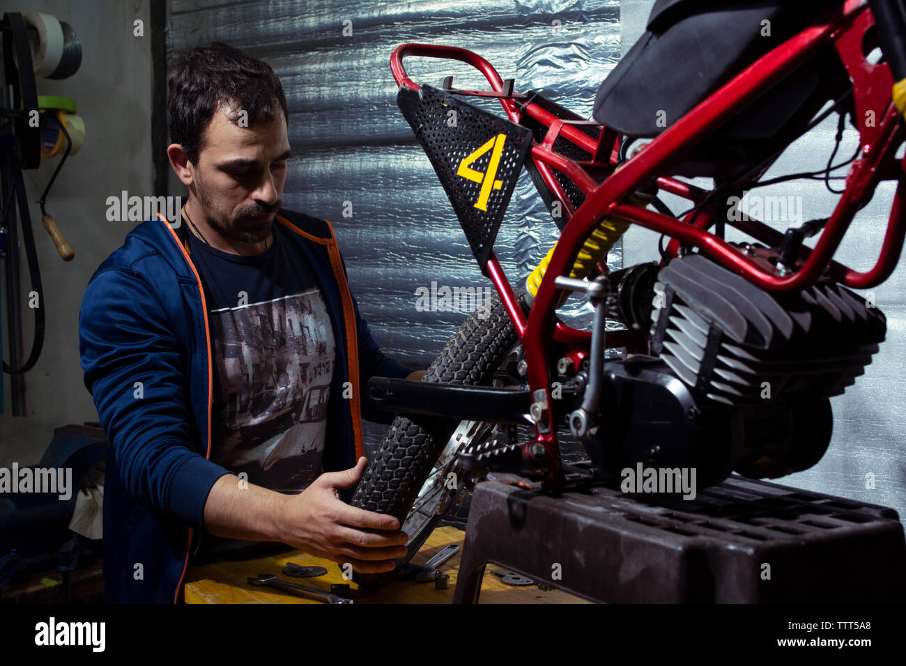 Mechanic repairing motorcycle at Stock Photo Alamy