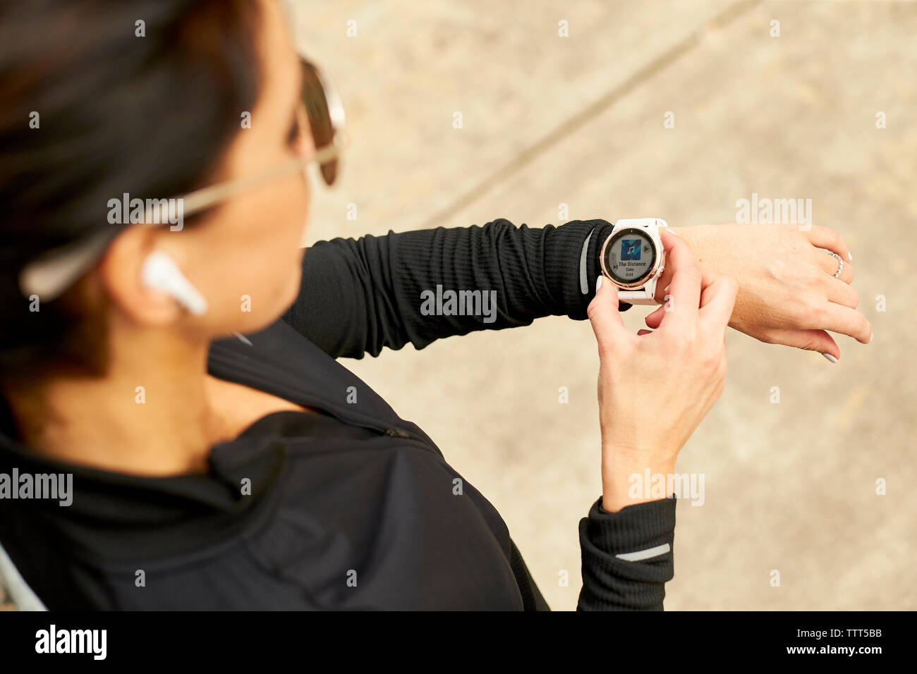 An overhead view of a woman selecting music on her smartwatch. Stock Photo